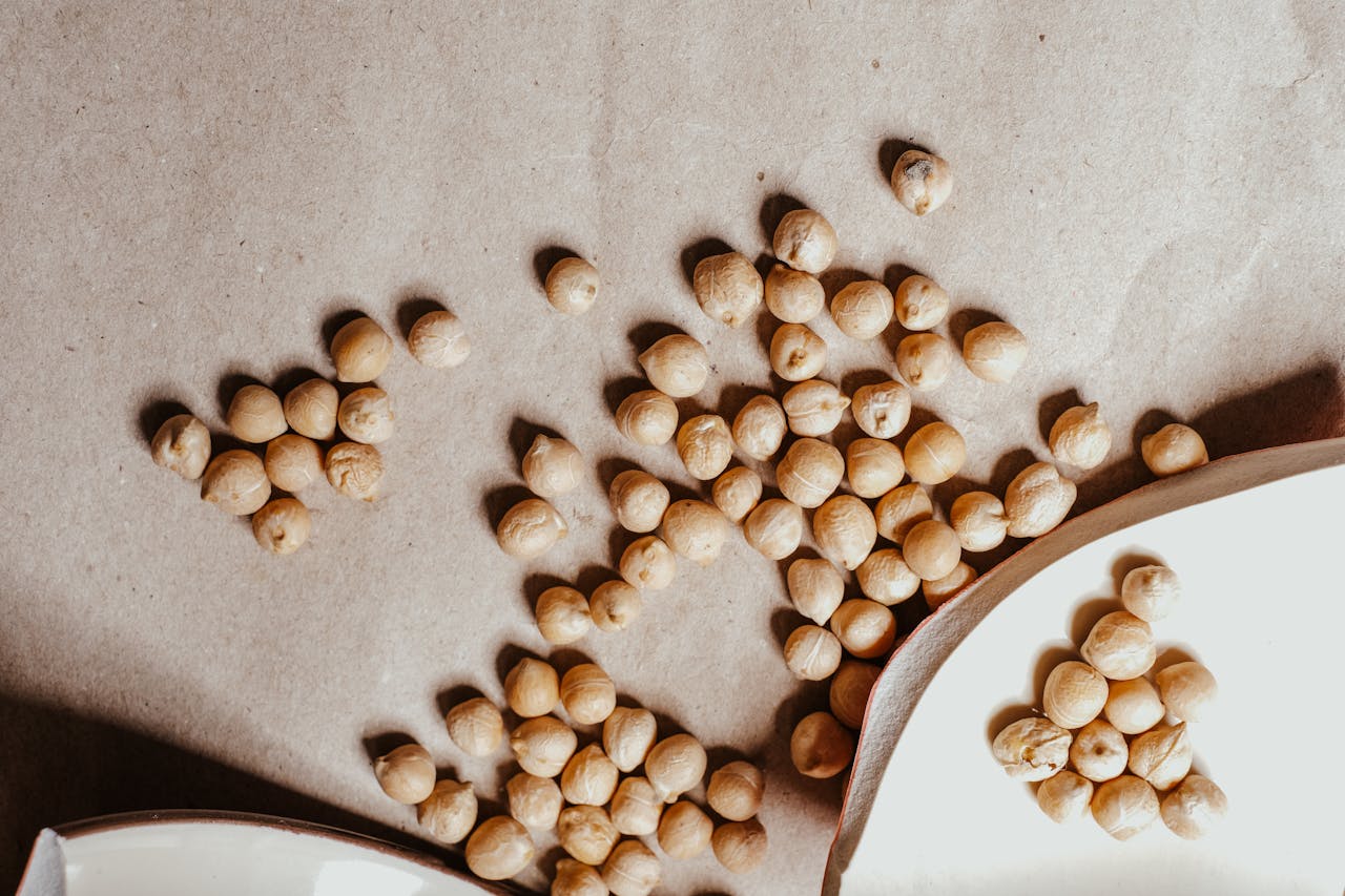 Close-up of dried chickpeas scattered on a textured brown surface, perfect for healthy food imagery.